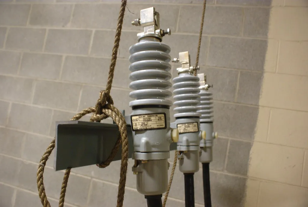 Closeup of three grey bushing terminators with a visible nameplate