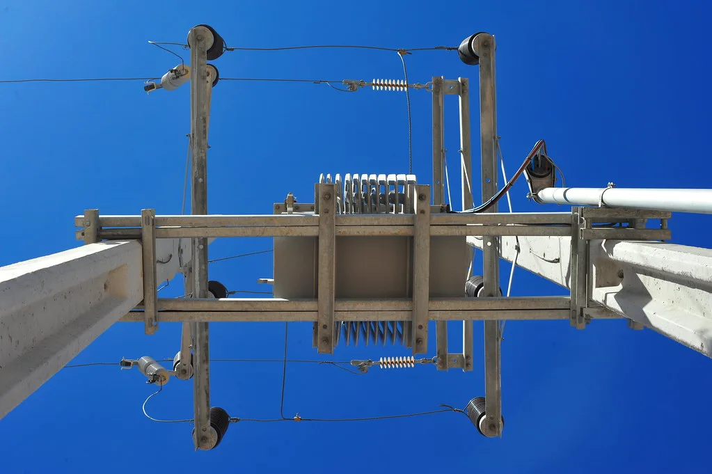 Pole-mounted distribution transformer seen from below
